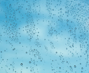 Raindrops on window of a ship at sea with clouds