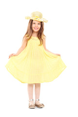 Full length portrait of little girl holding her yellow dress