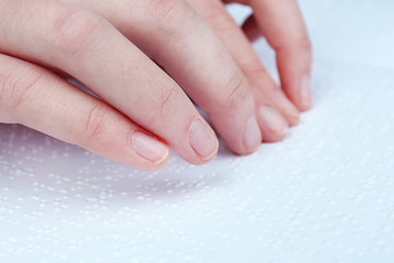 Blind woman read book written in Braille