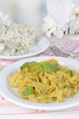 Delicious pasta with pesto on plate on table on light