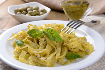 Delicious pasta with pesto on plate on table close-up