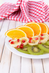 Sweet fresh fruits on plate on table close-up