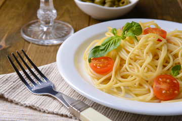 Delicious spaghetti with tomatoes on plate on table close-up