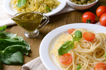 Delicious spaghetti with tomatoes on plate on table close-up