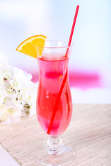 Glass of cocktail on table on light background