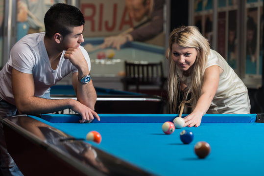 Young Couple Playing Pool Together