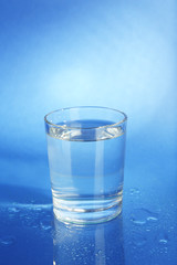Water in  glass, on dark blue background