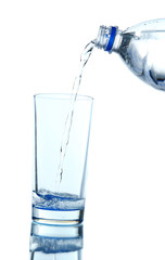 Pour water from bottle into  glass, on light blue background