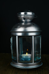 Decorative metallic lantern on wooden table on grey background