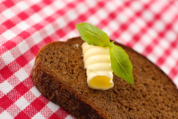 Slice of rye bread with butter, on tablecloth