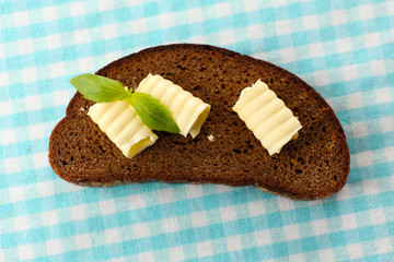 Slice of rye bread with butter, on tablecloth
