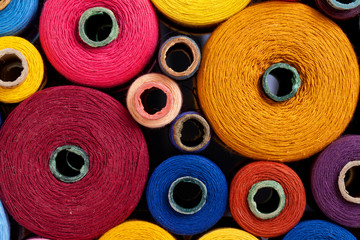 top view spools of thread of different size, texture and colour