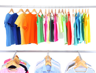 Different clothes on hangers, on gray background