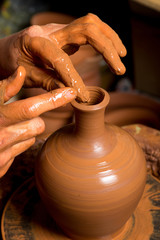 hands of a potter, creating an earthen jar