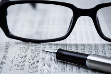 closeup glasses on financial newspaper