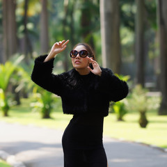 Beautiful Asian lady in black dress, posing in the park, greener