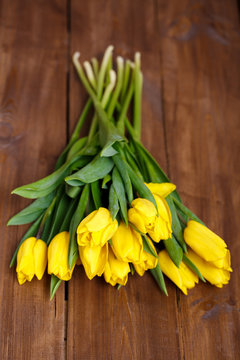 banch of Yellow tulips lying on wooden boards