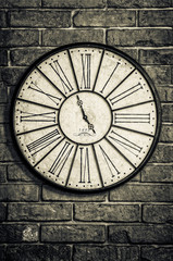 Fototapeta na wymiar Old vintage clock in monochrome on textured brick wall
