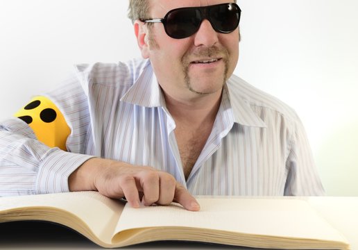 Mann mit Armbinde liest Braille Blindenschrift