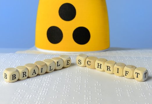 Holzw&uuml;rfel mit Armbinde und Blindenschrift
