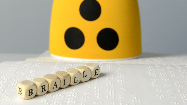 Finger ertasten Blindenschrift