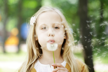 Cute child girl blowing dandelion - wishes