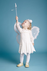 Cute little girl with butterfly costume on blue background