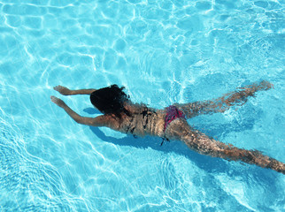 Young woman under water in the swimming pool.