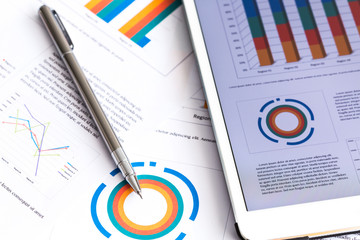 Obraz premium Financial charts on the table with tablet phone and pen