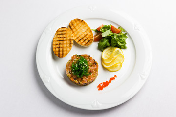 Fish tartare with vegetables and crackers