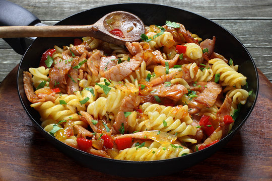 Fried pasta with pork ham and paprika