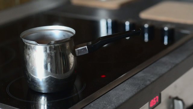 Coffee pot on cooking plate with boiling water in