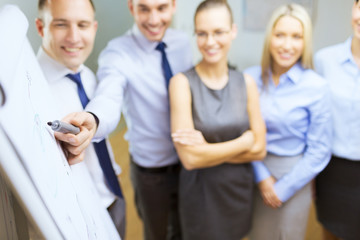 Obraz premium smiling business team with charts on flip board