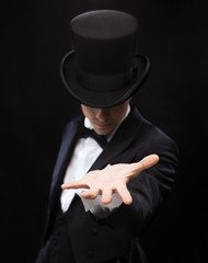magician holding something on palm of his hand - obrazy, fototapety, plakaty
