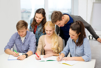 smiling students with notebooks at school