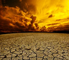 Poster Woestijnlandschap Bewolkte lucht en gebarsten grond © C.Castilla