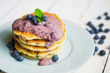 Blueberry pancakes on white wooden background