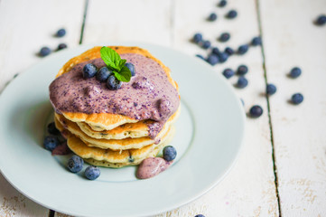 Blueberry pancakes on white wooden background