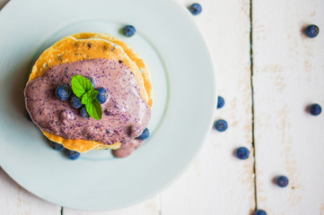 Blueberry pancakes on white wooden background
