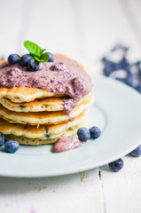Blueberry pancakes on white wooden background