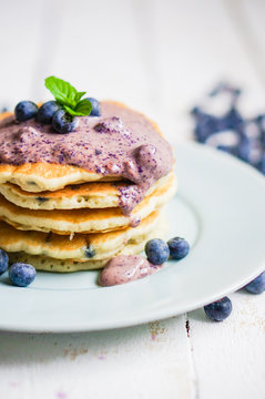 Blueberry pancakes on white wooden background
