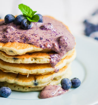 Blueberry pancakes on white wooden background