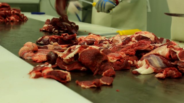 butcher chopping raw meat in the factory