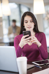 handsome woman using smartphone  in a cafe