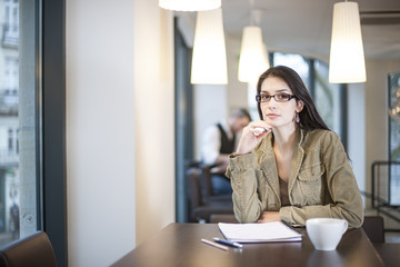 smart woman writing in a cafe