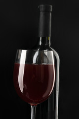 Wine glass and Bottle, isolated on black background.