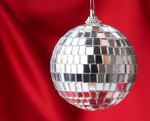 silver disco ball , isolated on red background.