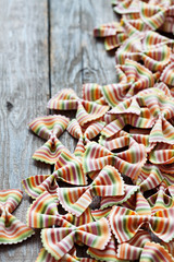 Colored pasta on wooden background
