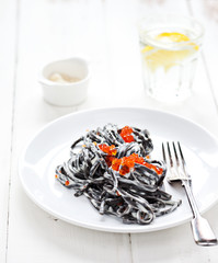 Black pasta with red caviar