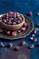 Fototapeta na wymiar Dry roses in wooden bowl